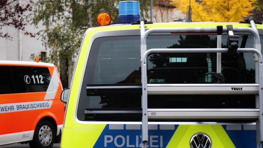 a yellow and blue police car parked next to a building