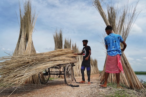 a couple of men standing next to a wooden cart