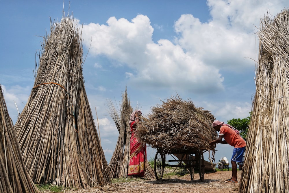 a group of people standing around a pile of hay