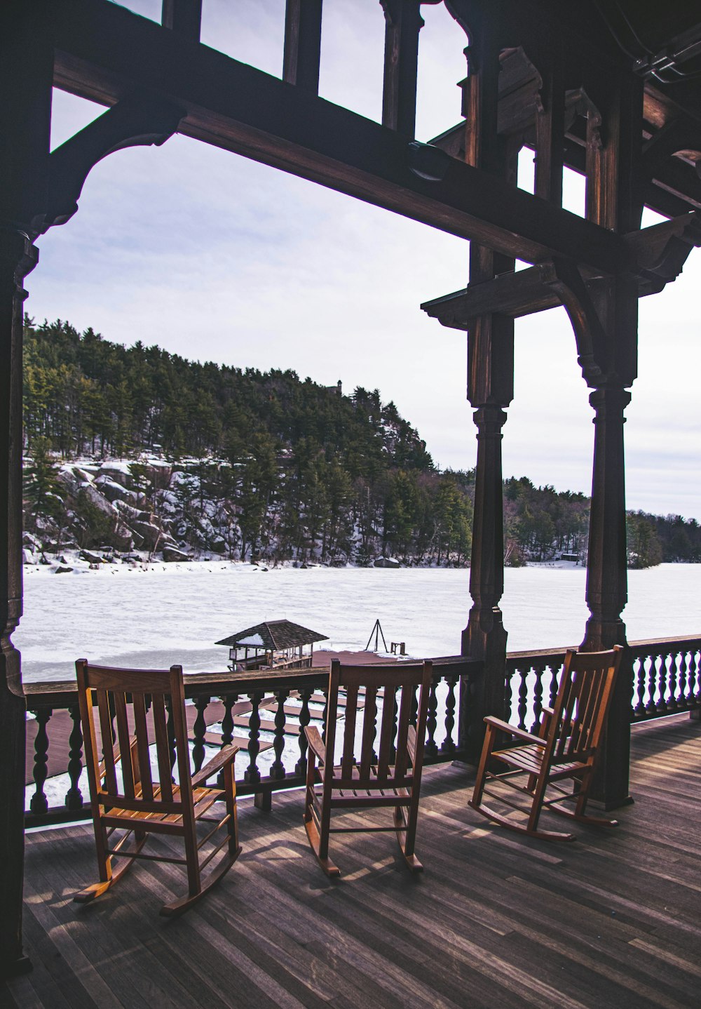 two wooden rocking chairs sitting on top of a wooden deck