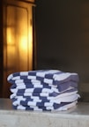 a stack of folded towels sitting on top of a counter