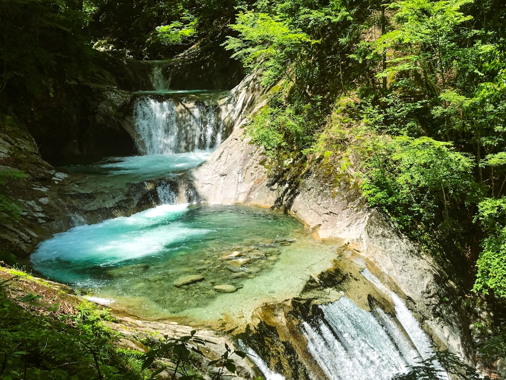 a waterfall with blue water surrounded by trees