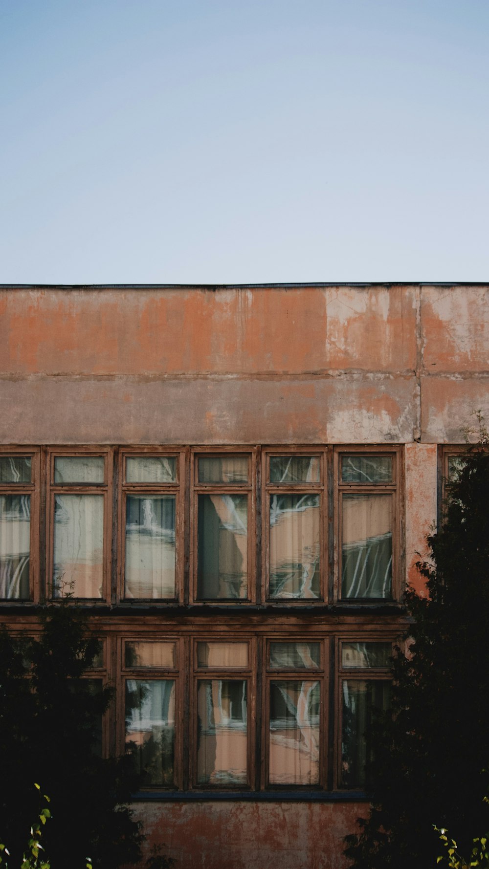 a tall building with lots of windows next to trees