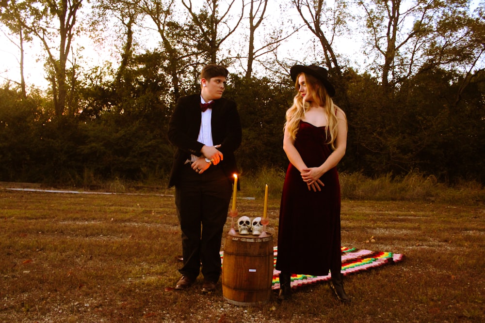 a man and woman standing next to each other in a field