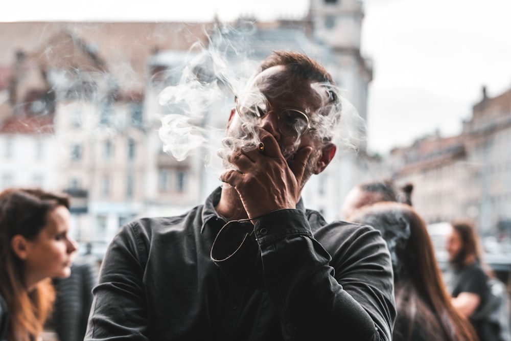 a man smoking a cigarette in a city