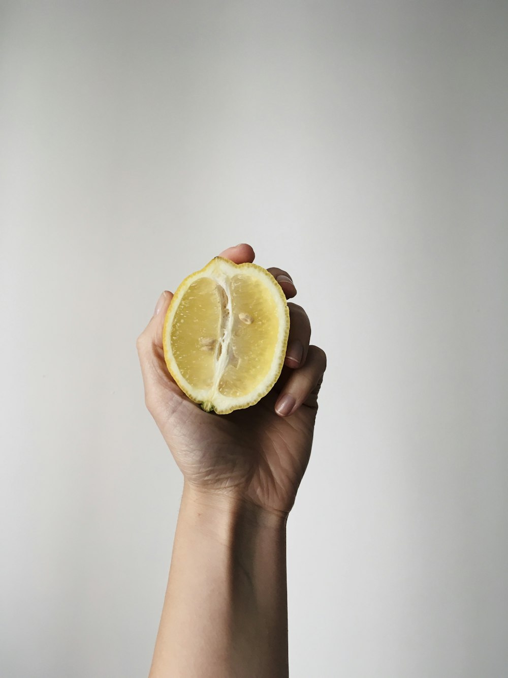 a person holding a half of a lemon in their hand