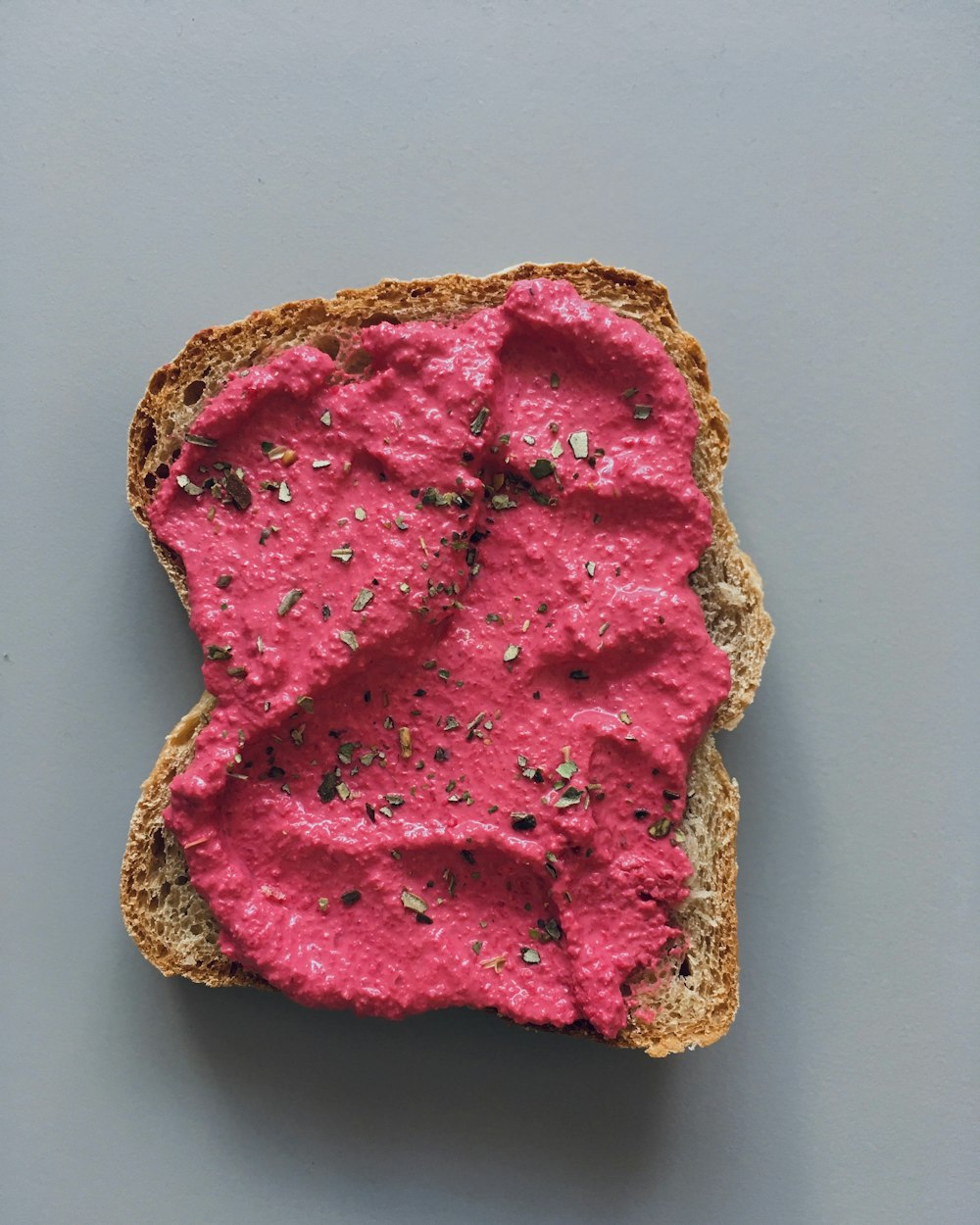 a piece of bread with a pink substance on it