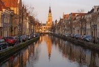 Sunset view over Amsterdam’s historic canal houses reflecting in the water.