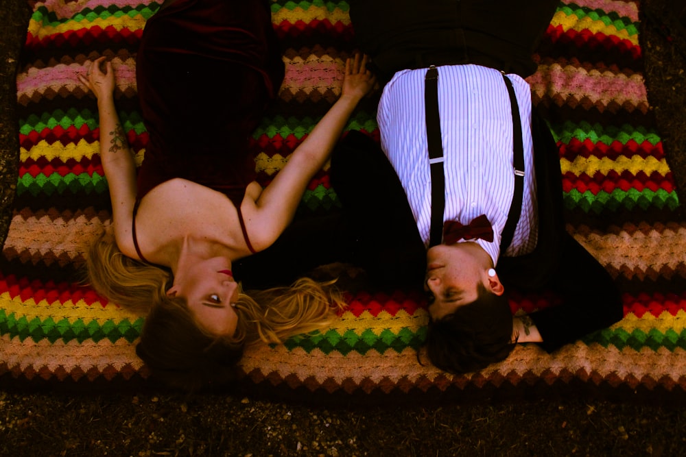 a couple of people laying on top of a blanket