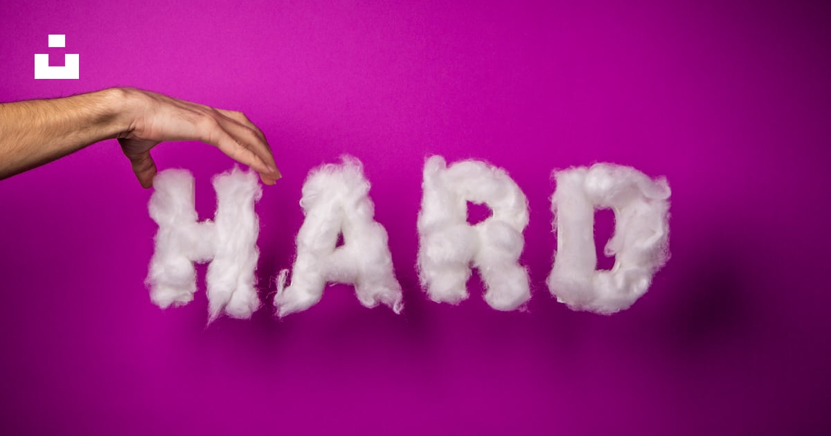 The word hard is written with clouds in front of a hand photo Free