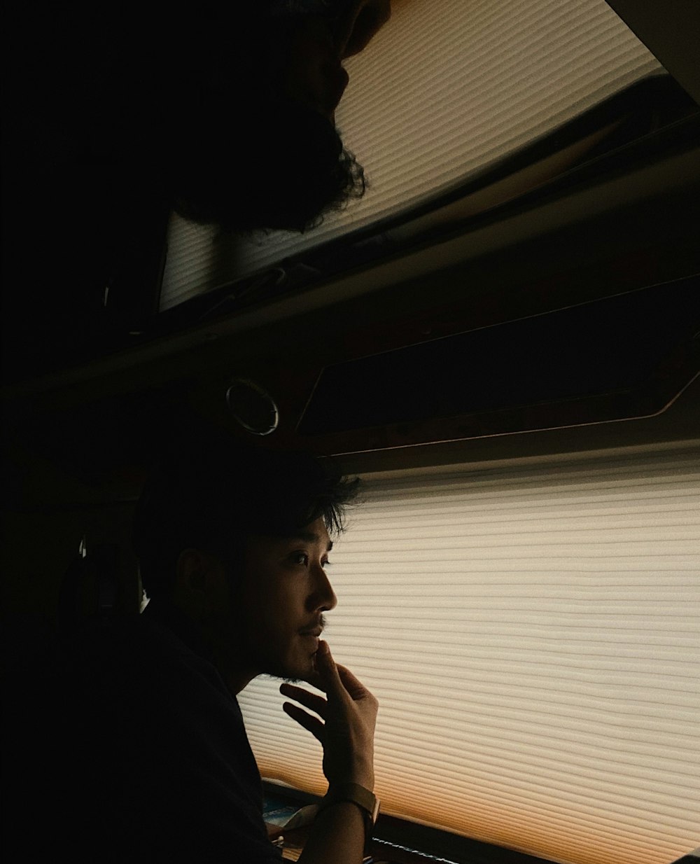 a man sitting in a car talking on a cell phone