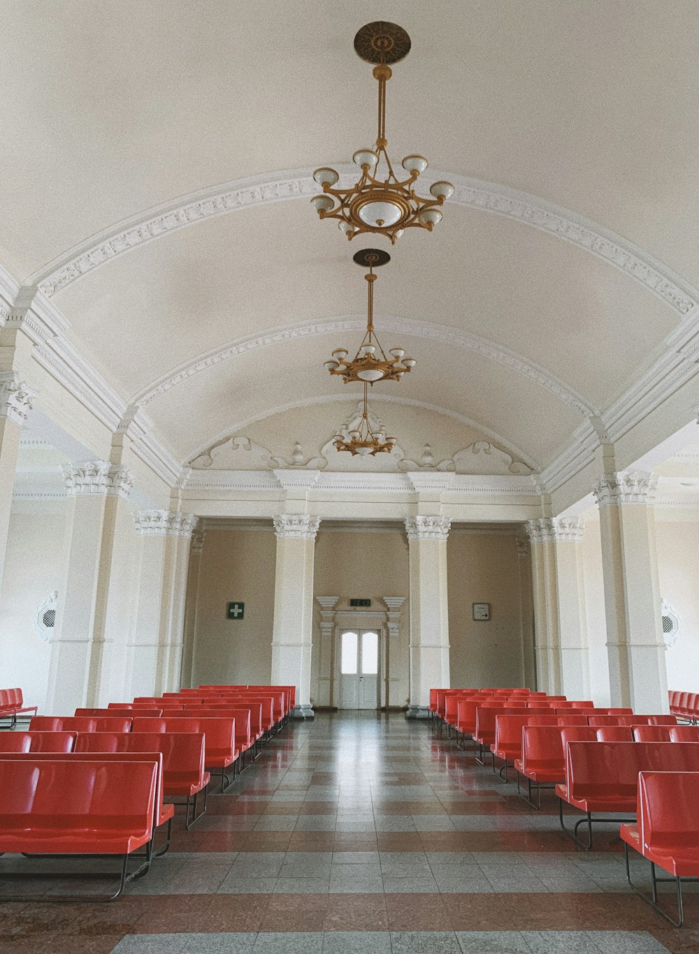 a room with red chairs and a chandelier