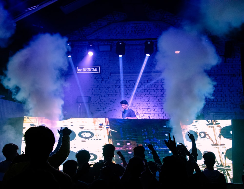 a man standing on a stage surrounded by smoke