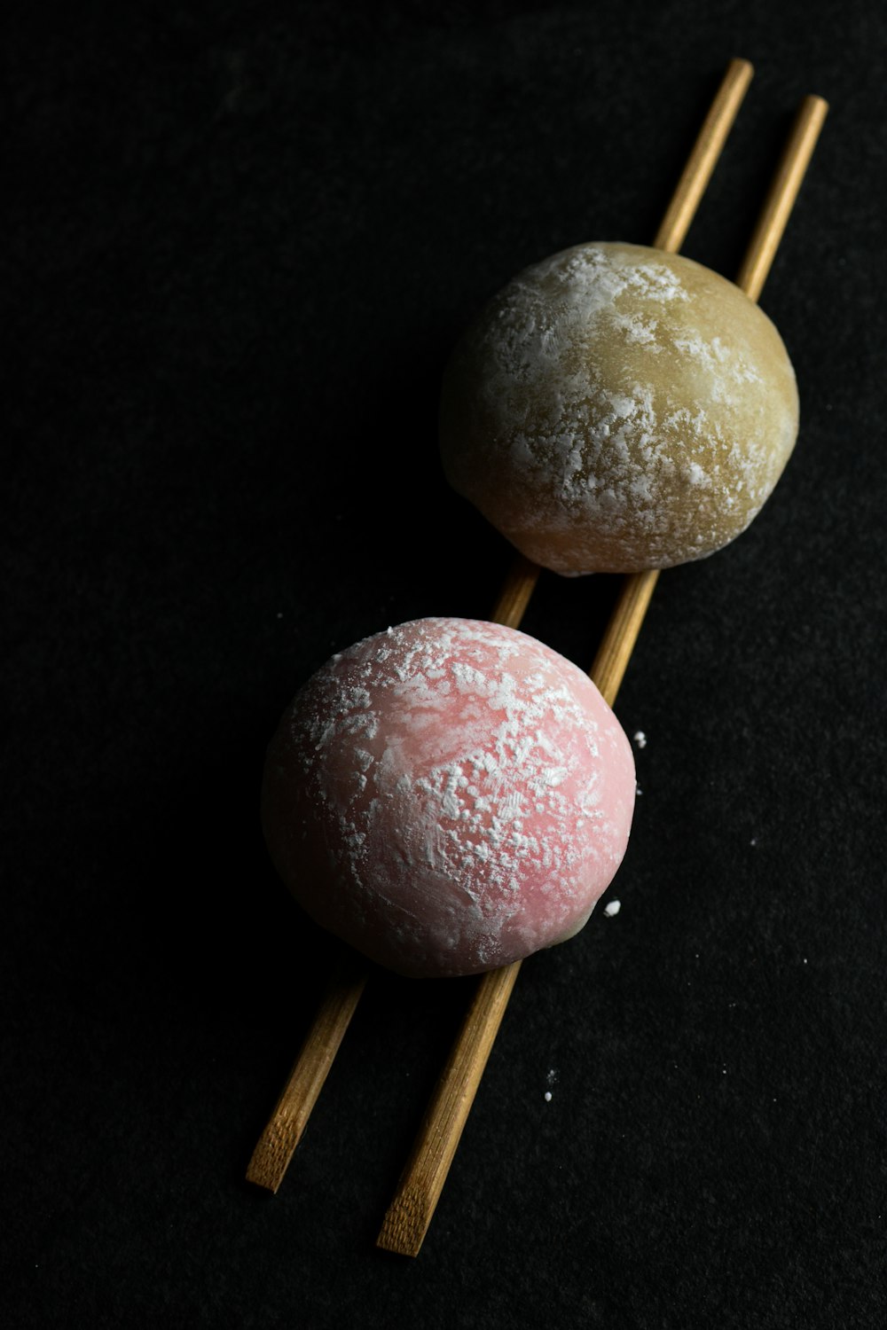 a couple of doughnuts sitting on top of wooden sticks