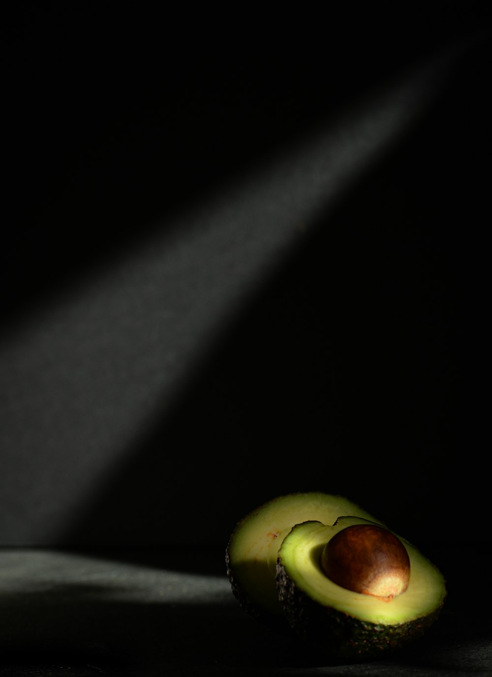 an avocado cut in half on a table