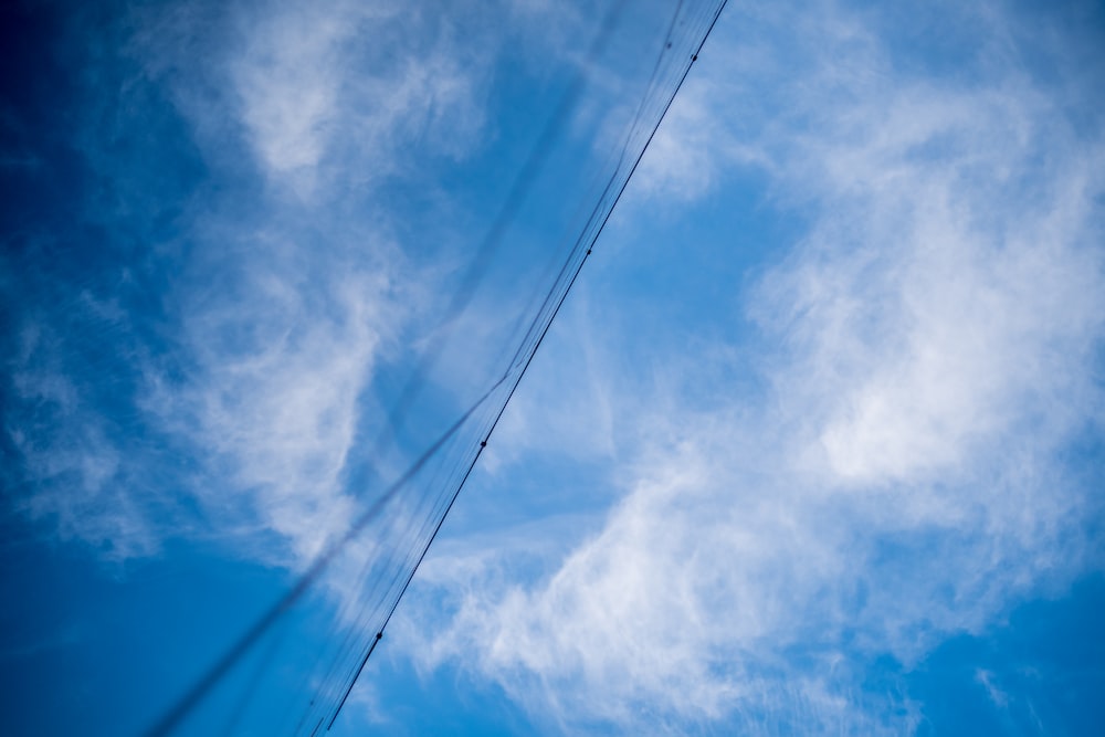 a blue sky with some clouds and a telephone pole