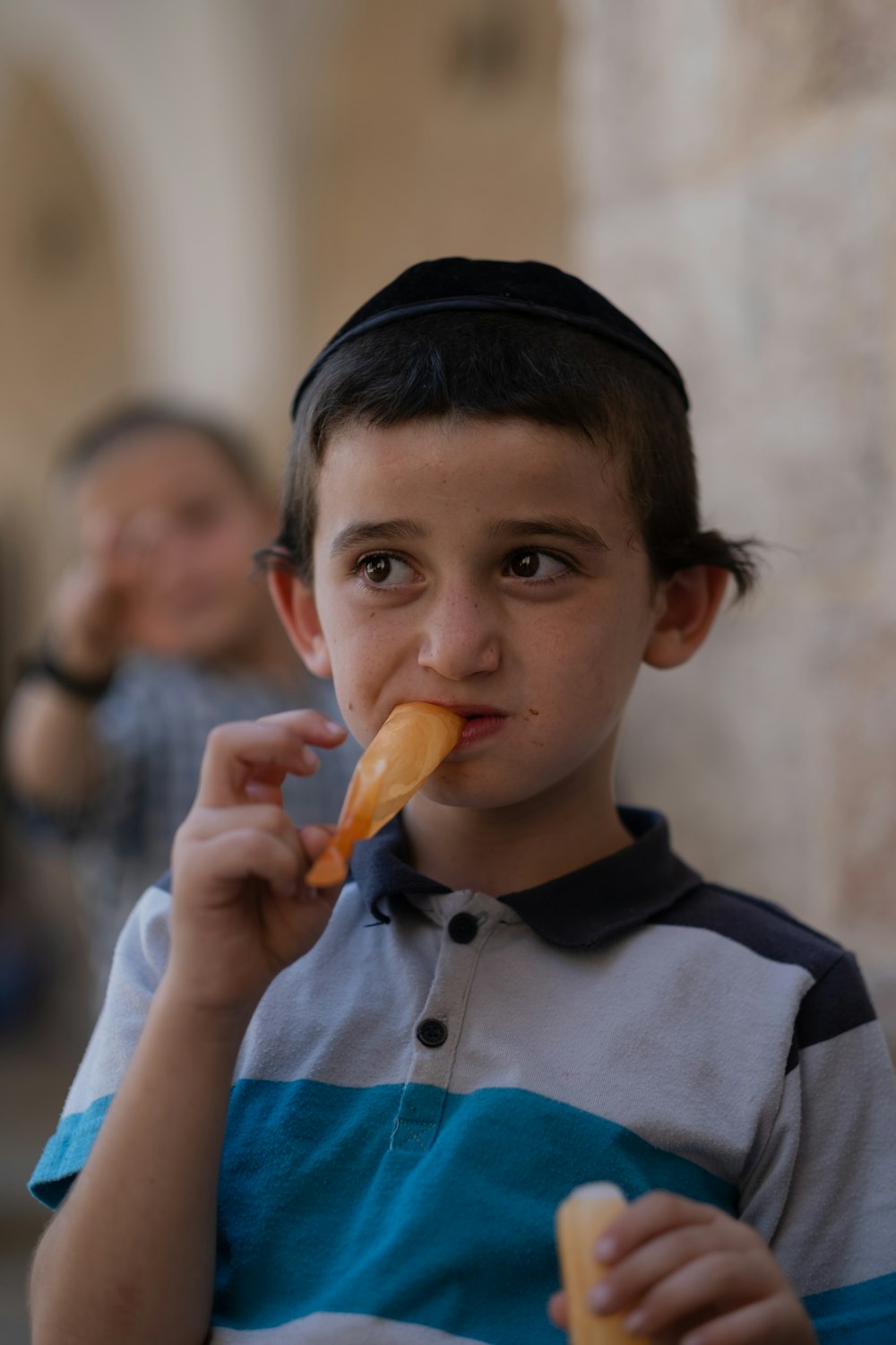a young boy is eating a hot dog