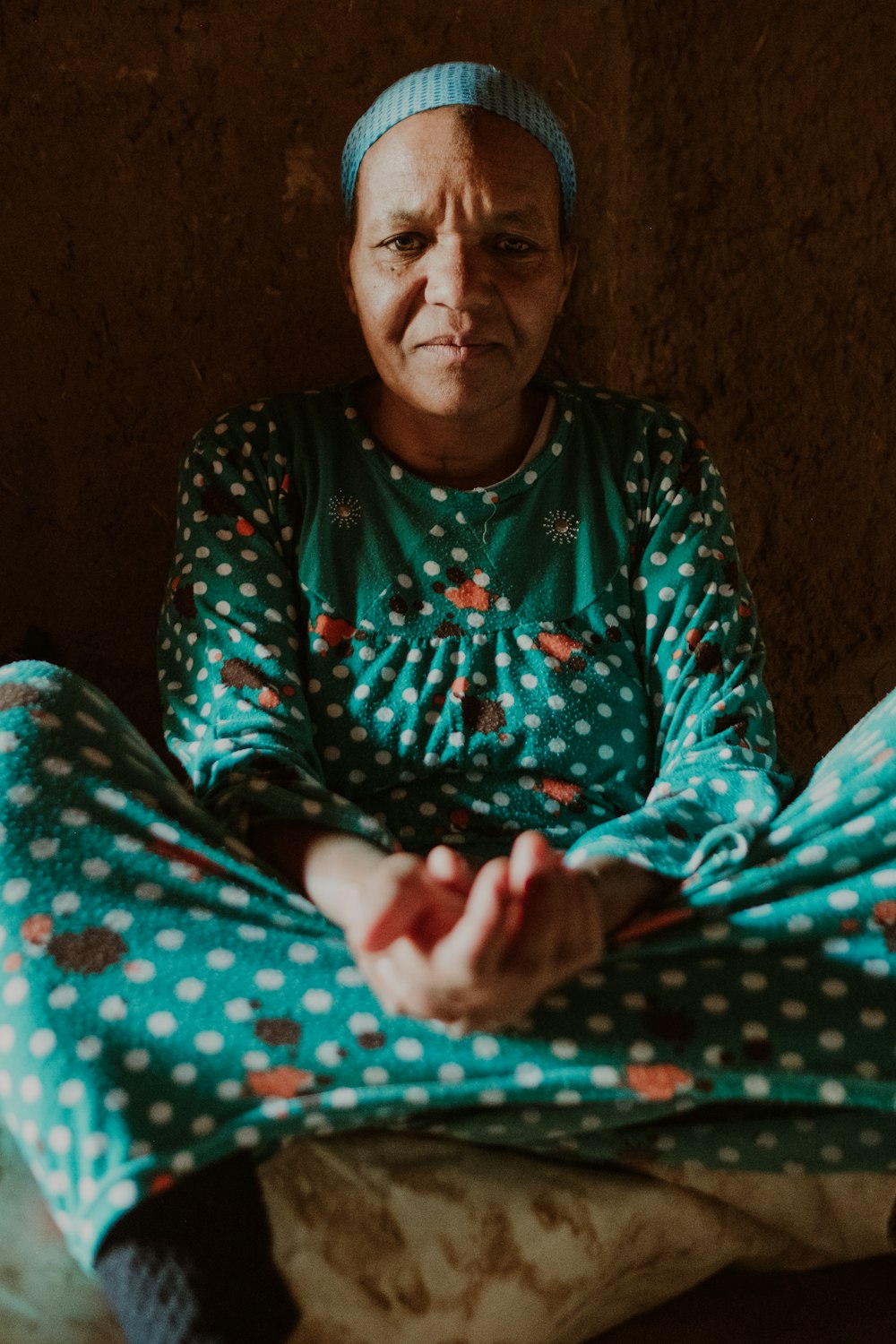 a woman sitting on the floor in a green outfit