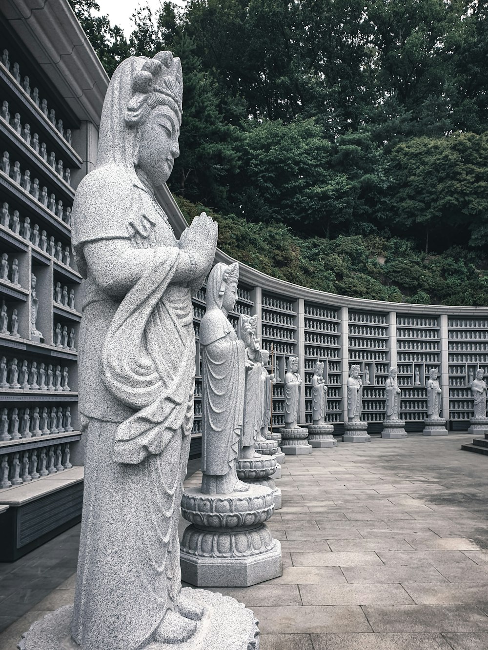 a row of statues of buddhas in front of a building