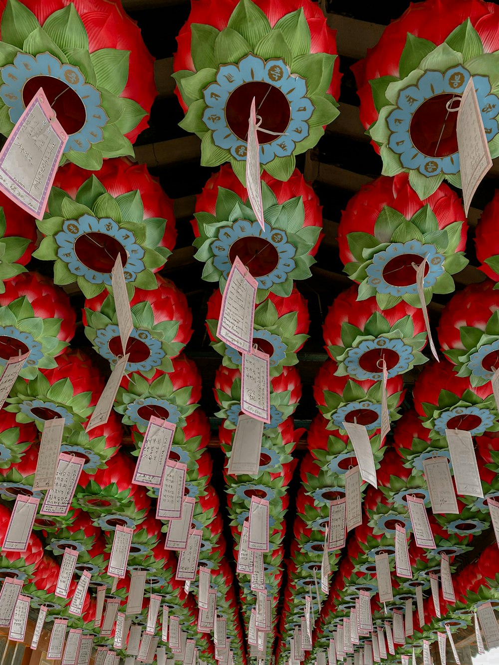 a bunch of red and green decorations hanging from a ceiling