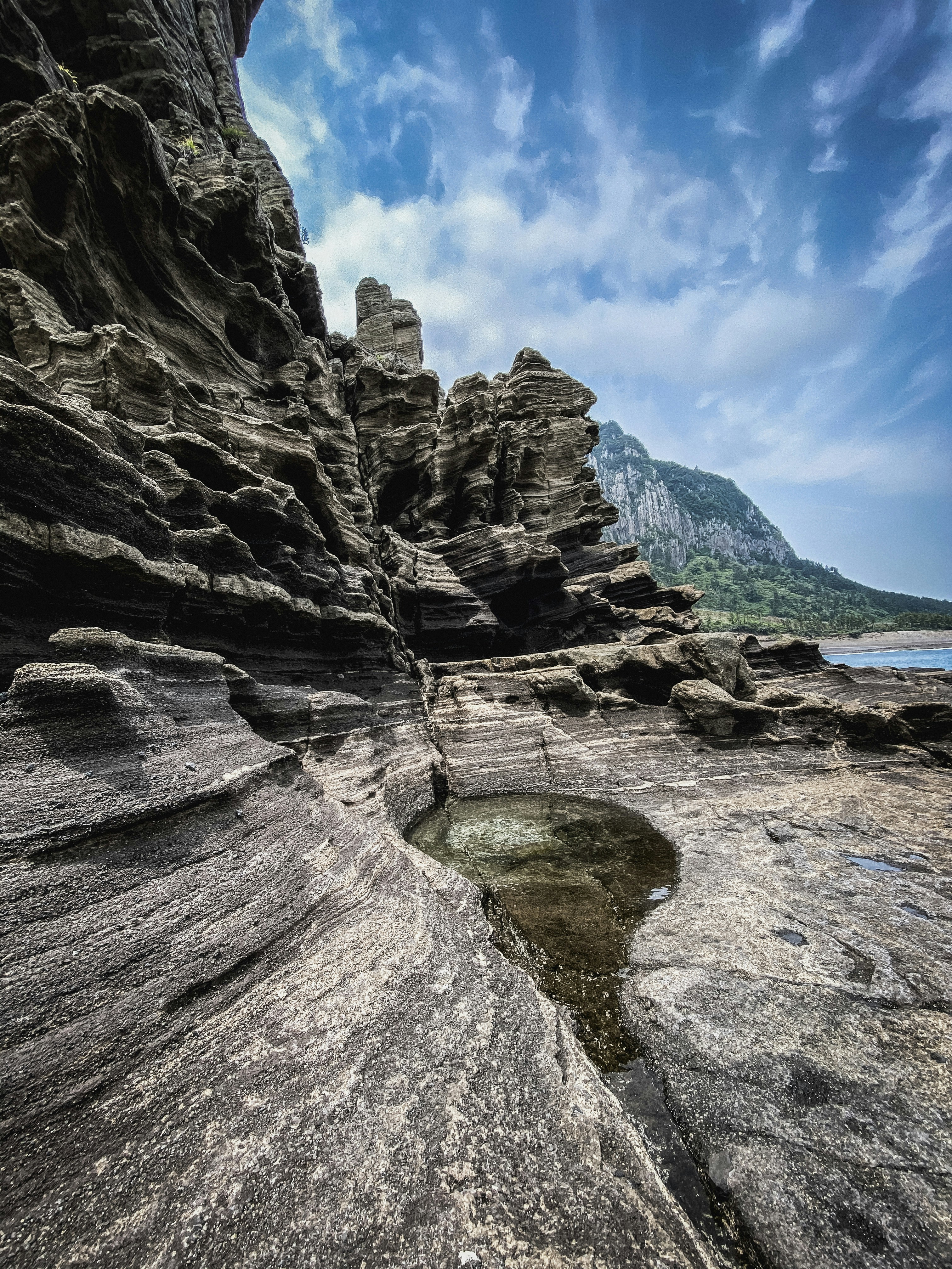 a rock formation with a small pool of water in the middle of it