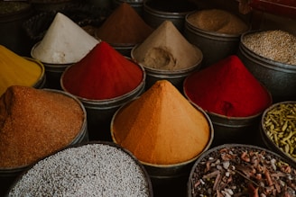 a variety of different colored spices in bowls