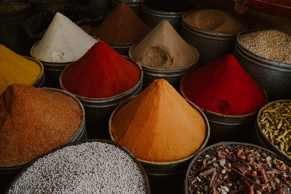 a variety of different colored spices in bowls