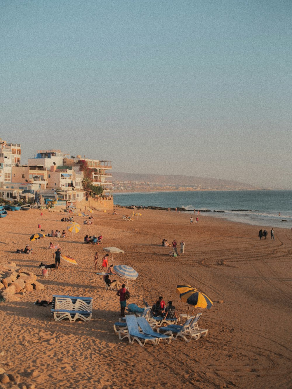 um grupo de pessoas sentadas em cima de uma praia de areia