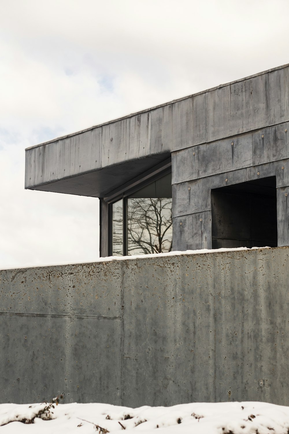 a concrete building with a tree in the background