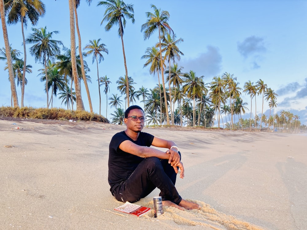 a man sitting on a beach with palm trees in the background