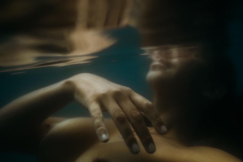 a woman with her hand on her chest under water