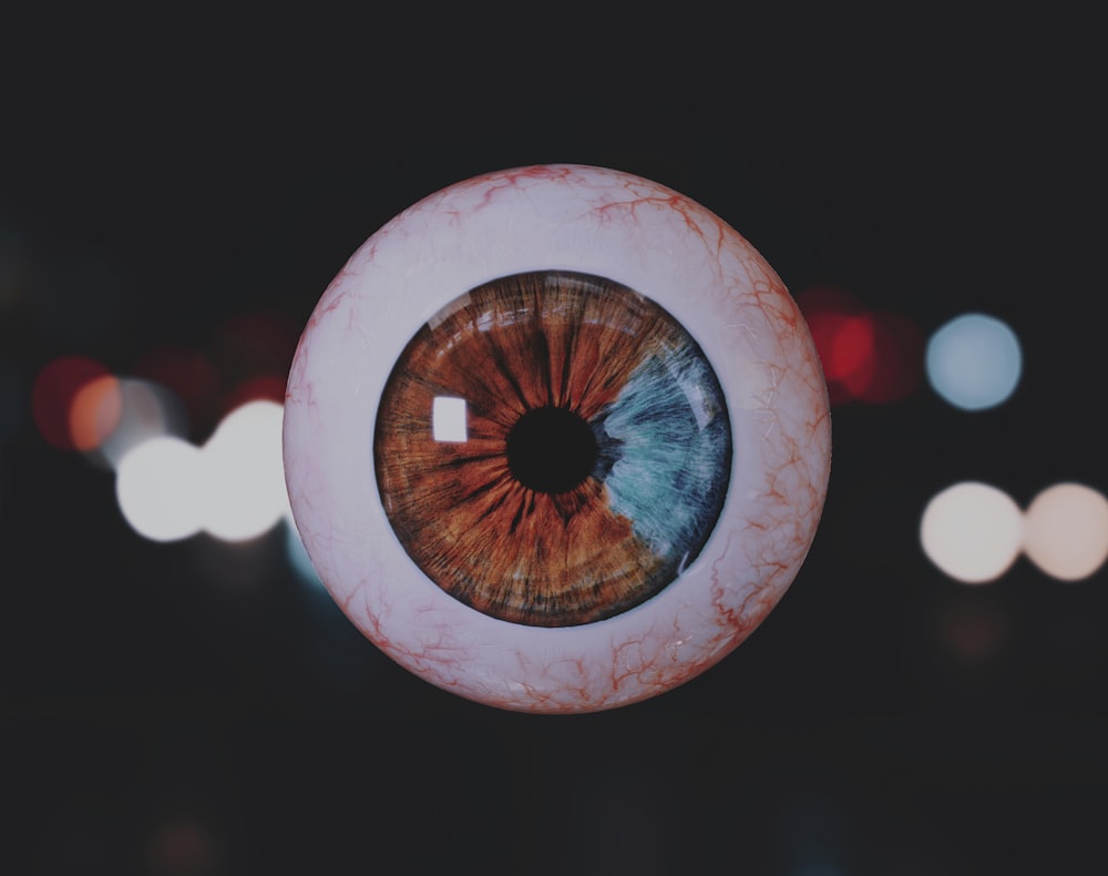 a close up of an eyeball with blurry lights in the background