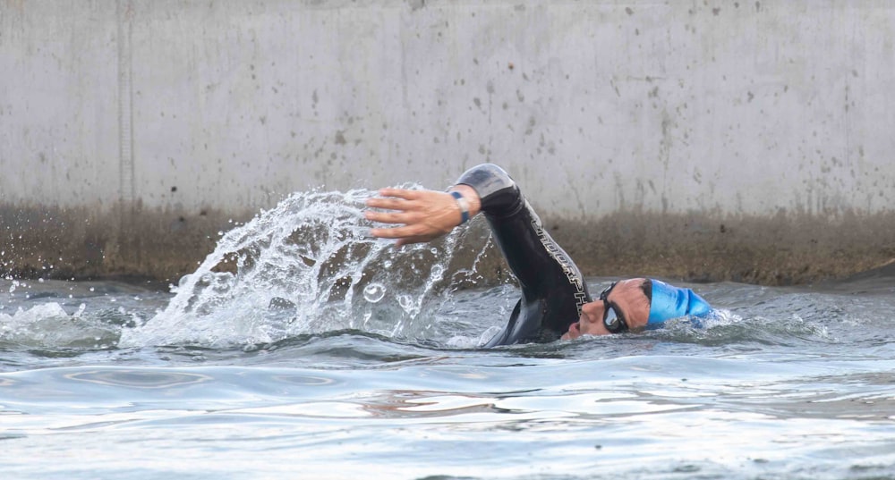 a man in a wet suit swimming in the ocean