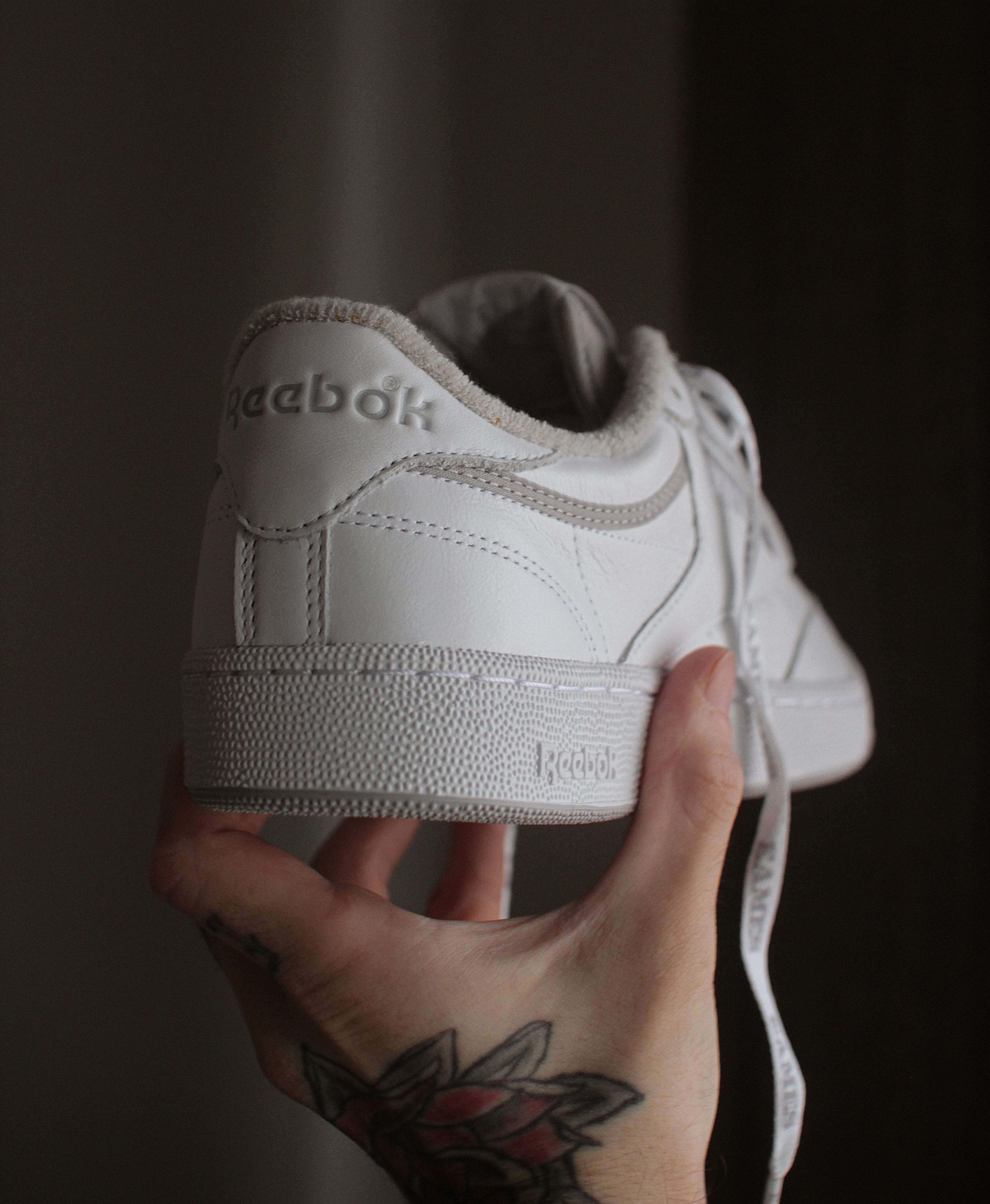 a person holding a white shoe in their hand