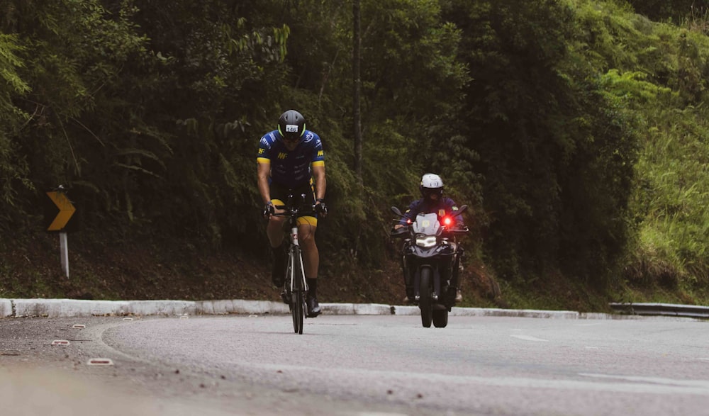 Un par de personas montando en bicicleta por una carretera