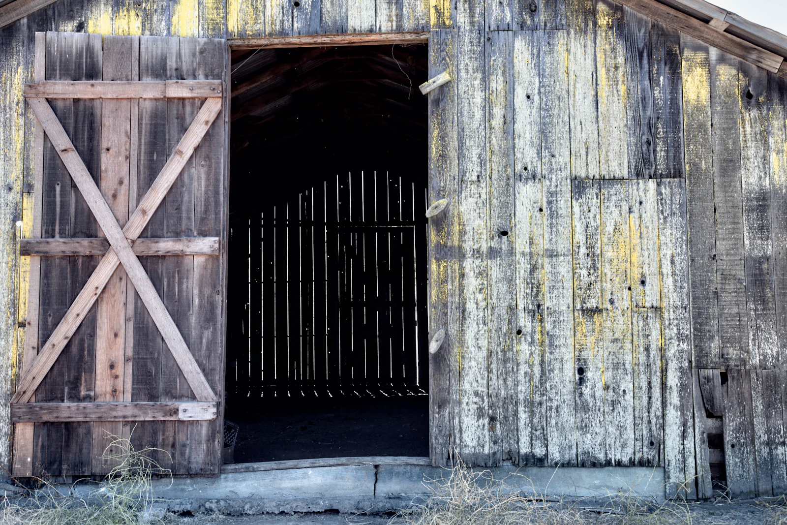 Weathered barn doors standing open on a dark interior.