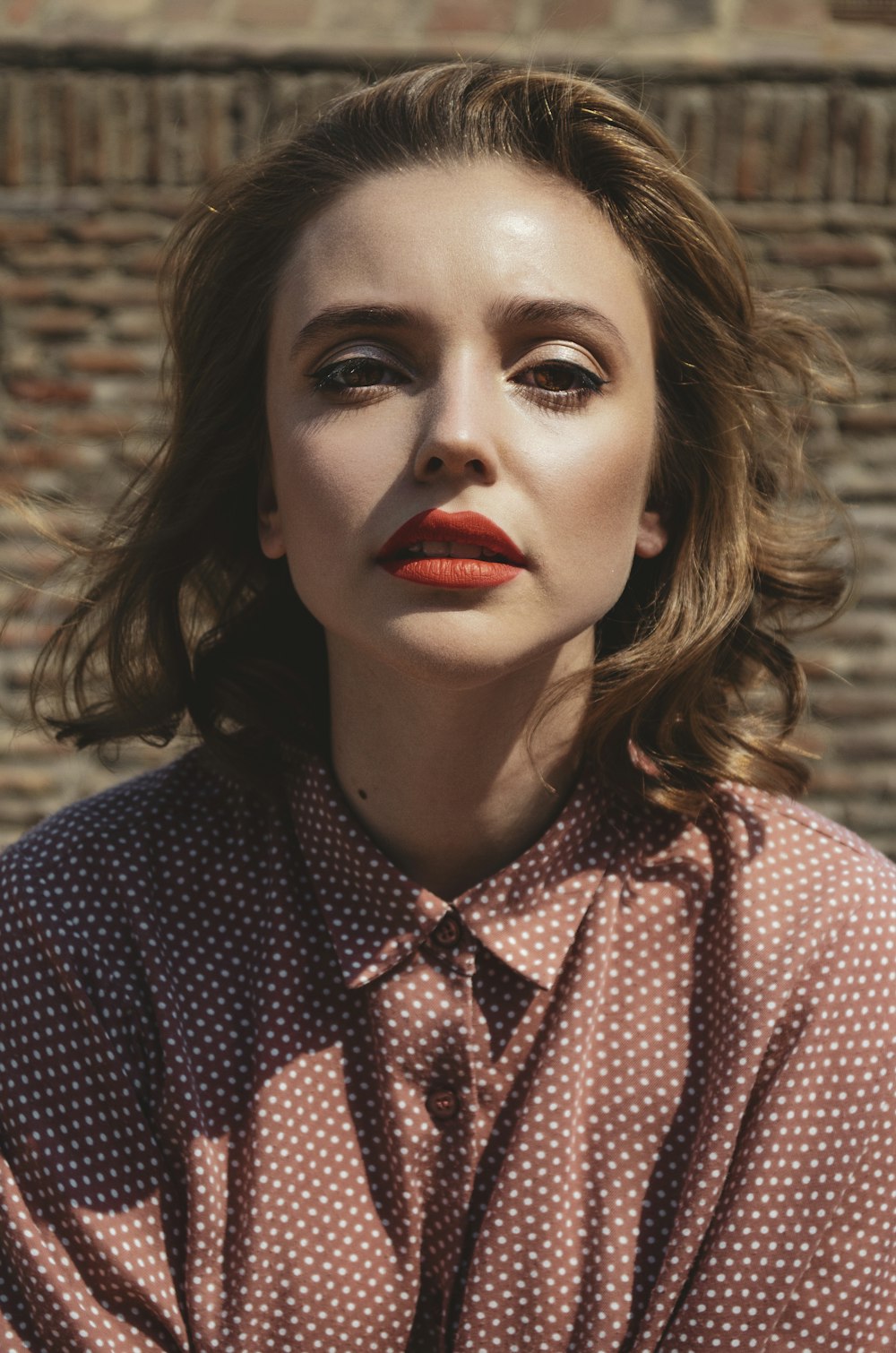 a woman in a shirt and tie with red lipstick