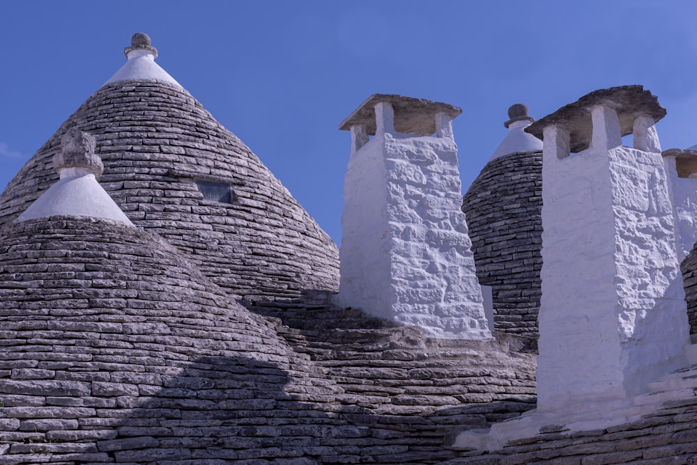 a stone building with three chimneys and a bird on top