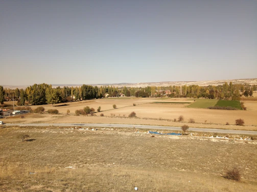 Peaceful rural parcel with open fields and a clear blue sky overhead.