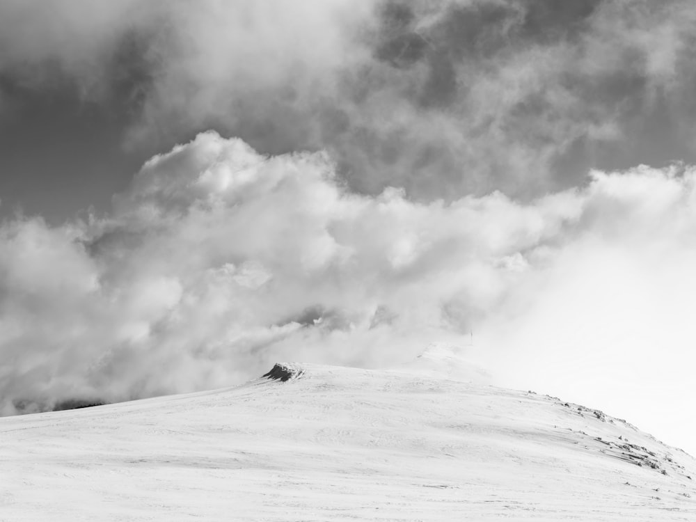 a black and white photo of a snow covered hill