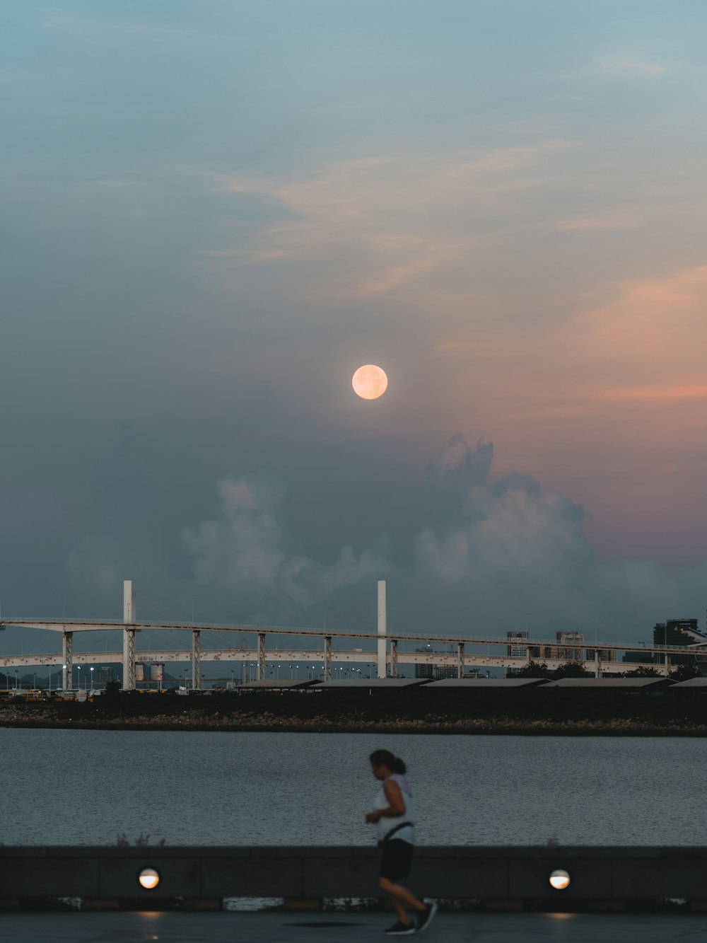 a person running on a sidewalk near a body of water