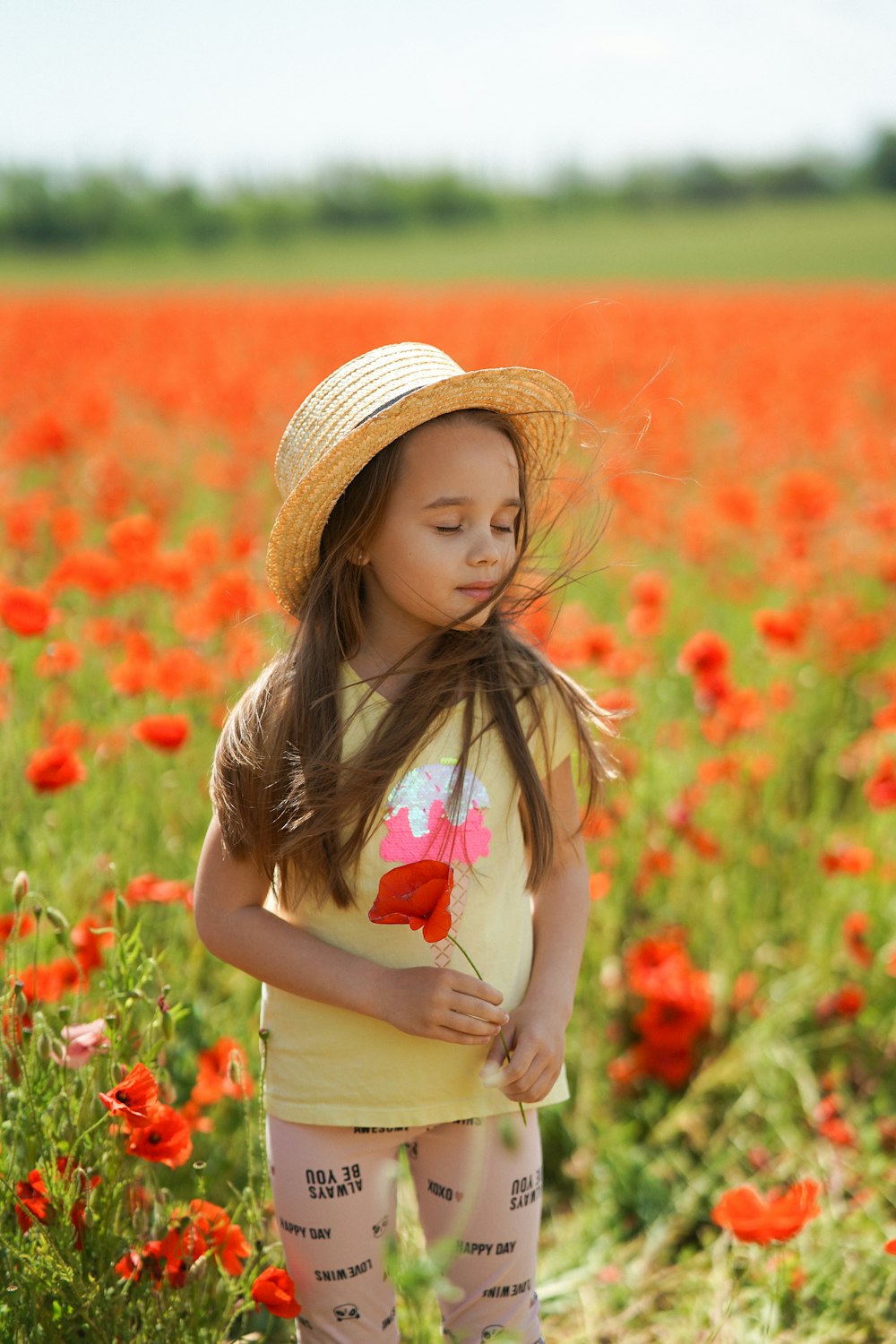 a little girl standing in a field of flowers