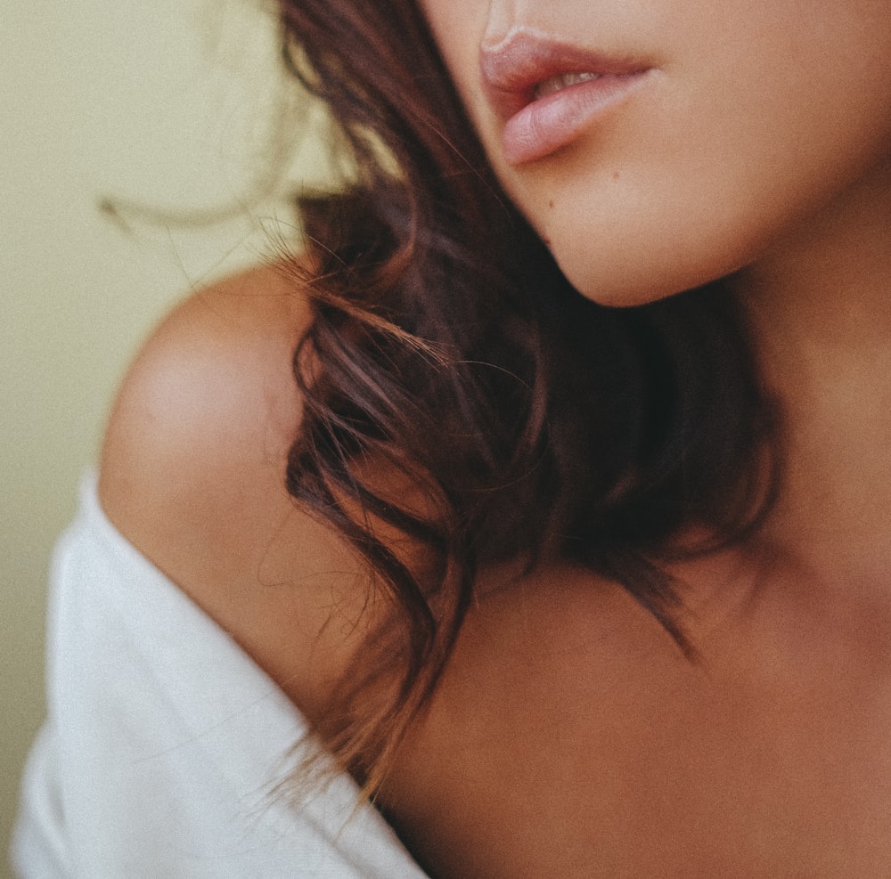 a close up of a woman's face and shoulder