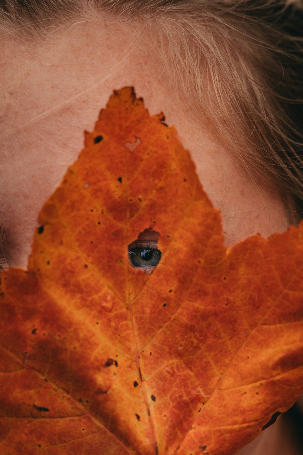 a woman with a leaf on her face