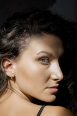 A close-up shot of a young woman with natural lighting highlighting her curves.