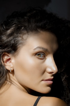 A close-up shot of a young woman with natural lighting highlighting her curves.