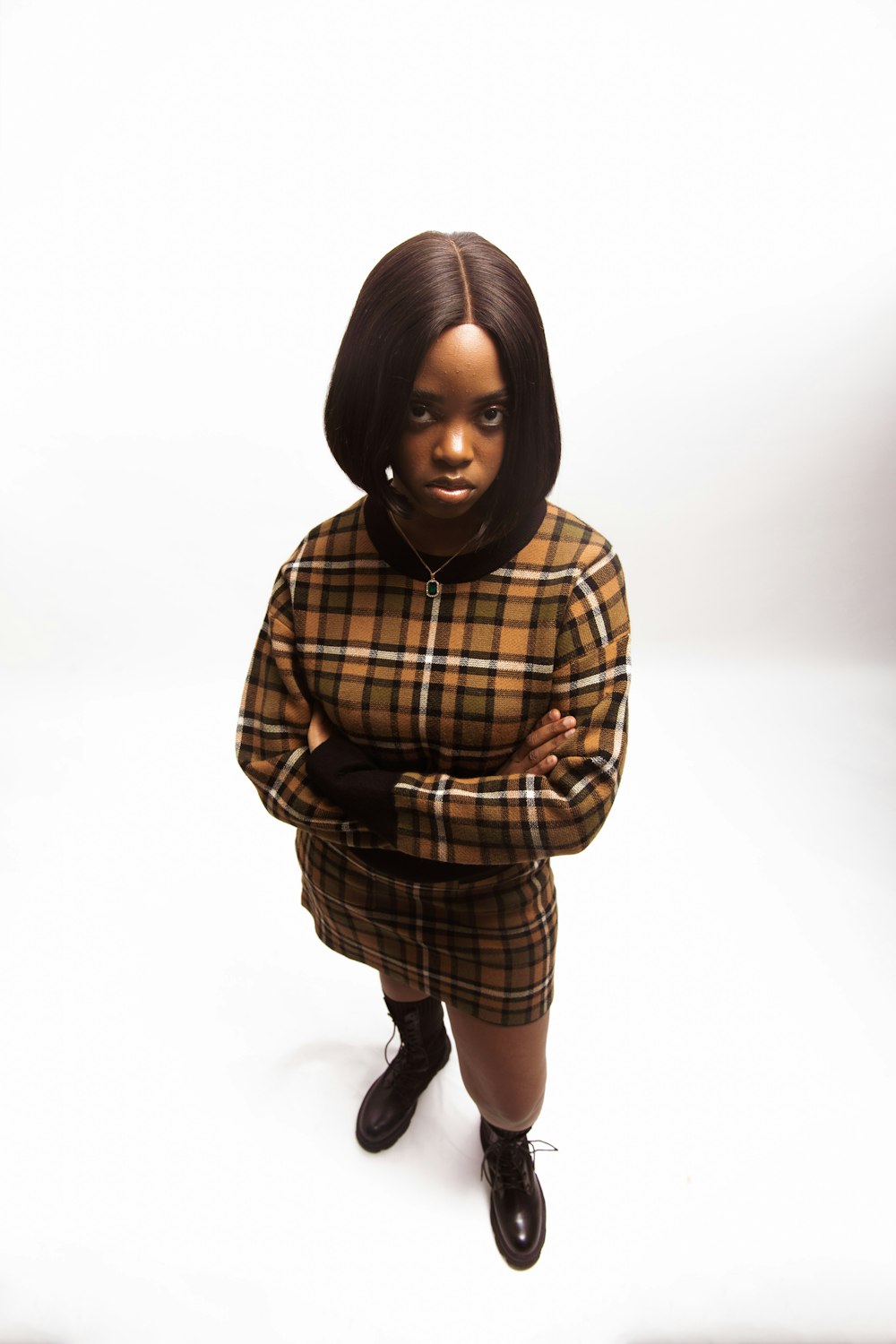 a black woman in a plaid shirt and skirt