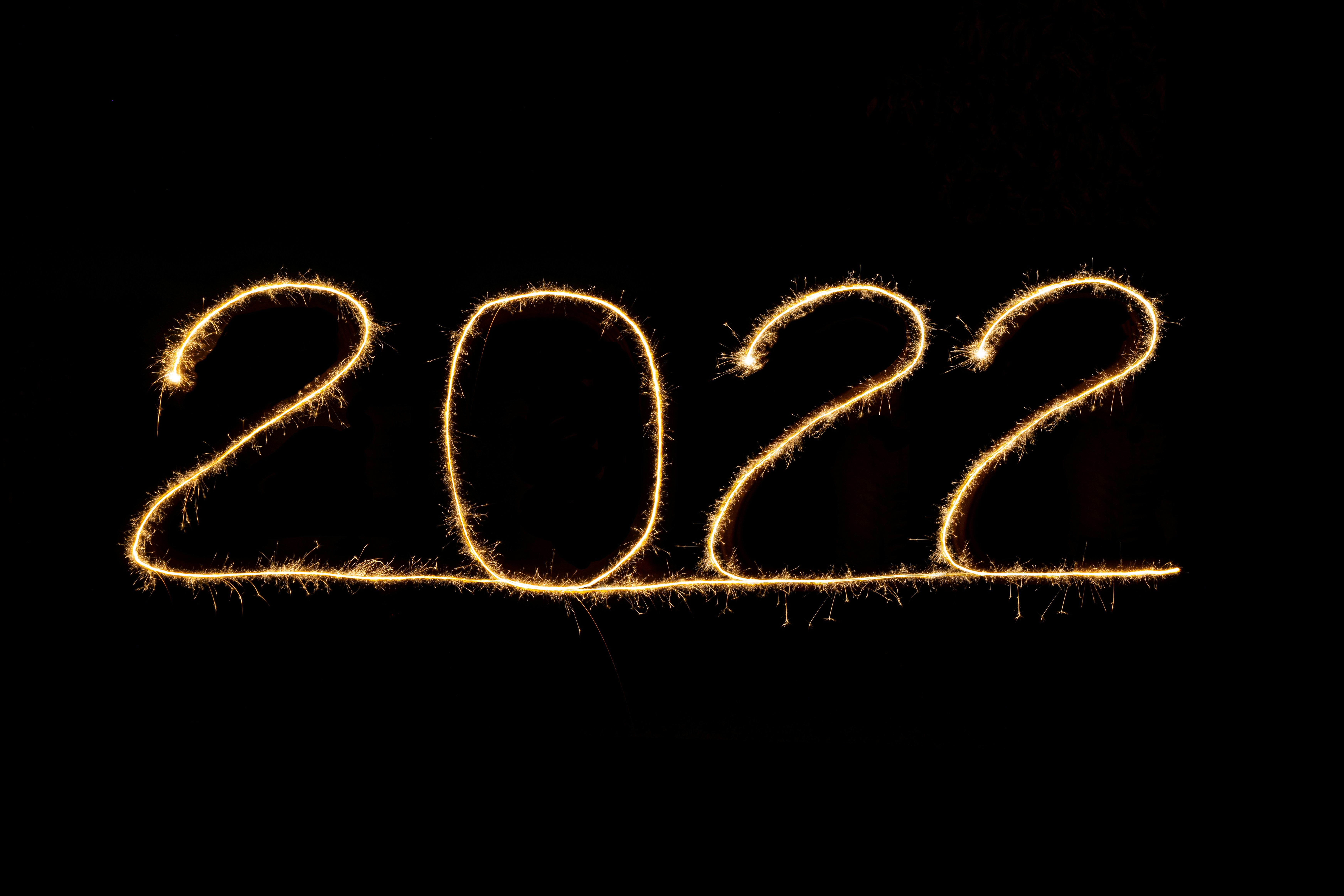 happy new year 2022, lightpainted 2022 on black background, greetingcard template, space for text, burning sparkler light 2022
