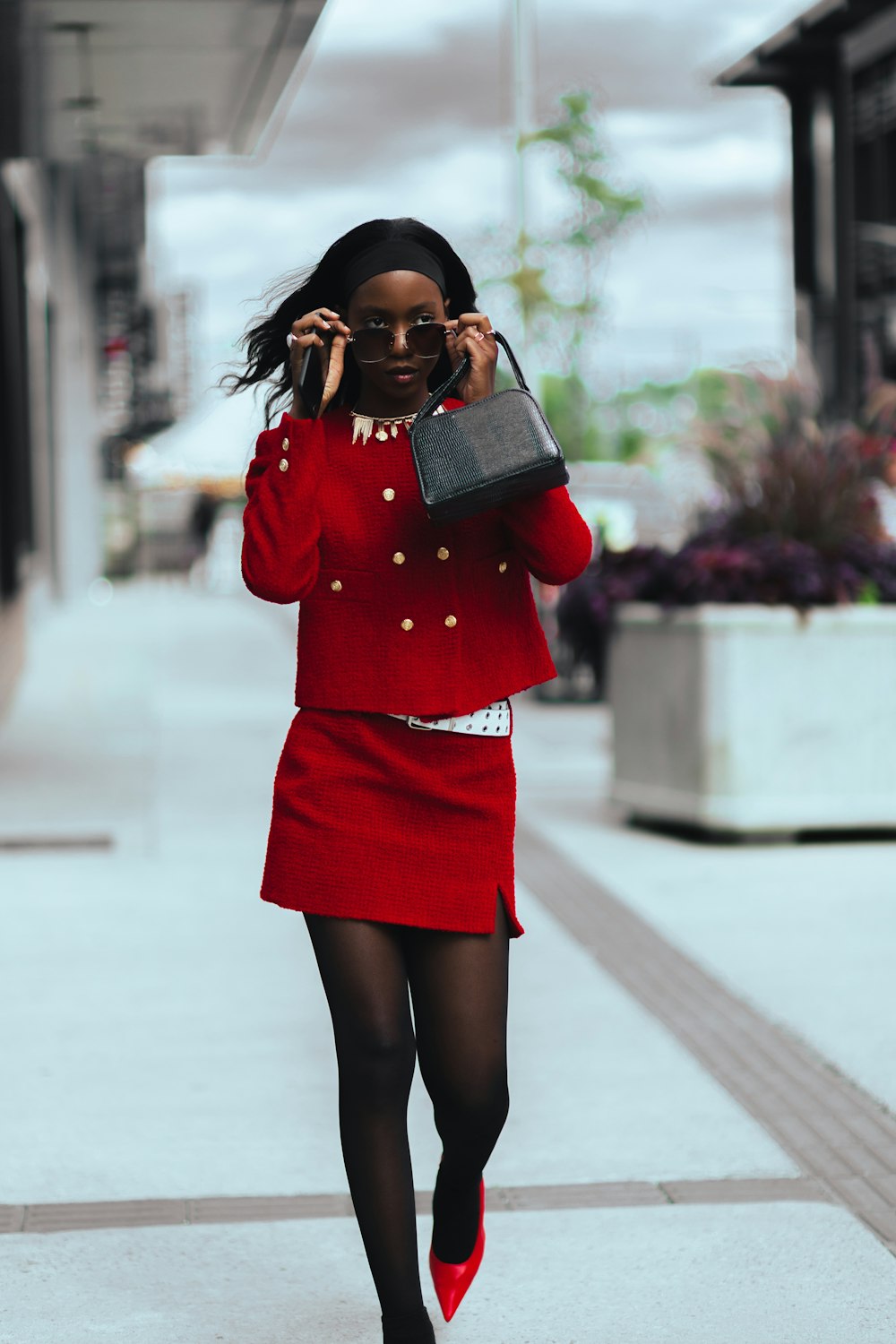 a woman walking down a sidewalk while talking on a cell phone