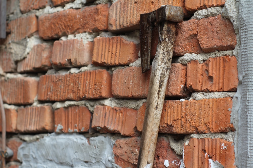 un mur de briques avec un marteau qui en sort